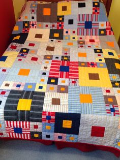 a bed with a colorful quilt on top of it