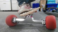 a person riding a skateboard on top of a carpeted floor with red wheels