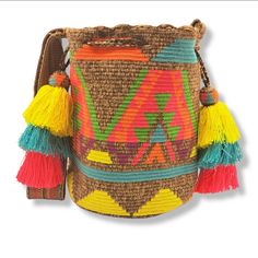 Magestic large traditional Wayuu backpack, beige background color, ethnic design in vibrant tropical colors, sash-type woven handle in the same hue as the backpack, decorated with braided cord with bell-ringers in the same color as the handle. Woven 100% by hand by our indigenous artisans from the Wayuu community of the Colombian Alta Guajira. -Material: Industrial wool -Height: 11.5" -Width: 12in -Length: 8in -Handle: 41 in long x 2.5in wide *The measurements of this product may vary slightly, Traditional Multicolor Bucket Bag With Adjustable Strap, Artisan Multicolor Bucket Bag With Adjustable Strap, Bohemian Beige Backpack, Multicolor Woven Bucket Bag For Travel, Bohemian Multicolor Bucket Bag For Travel, Multicolor Weaving Bucket Bag For Travel, Traditional Multicolor Woven Bucket Bag, Bohemian Yellow Woven Bags, Yellow Bohemian Woven Bags