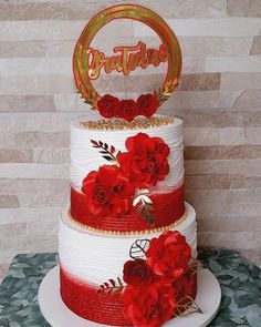 a three tiered cake with red flowers on top and the word brother spelled in gold