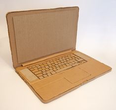 an open laptop computer sitting on top of a white table next to a cardboard box