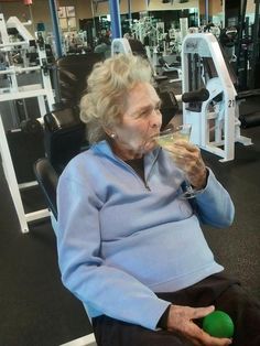 an older woman sitting in a gym chair drinking from a wine glass with the caption, my grandma's idea of working out