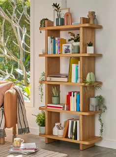 a living room filled with lots of books and plants