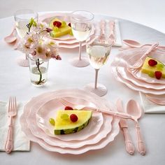 a table set with plates, glasses and utensils