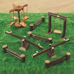 several pieces of wood are arranged in the shape of swings and ladders on green grass