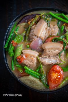 a bowl filled with meat and vegetables on top of a table