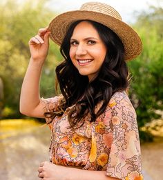 a woman in a hat is smiling for the camera