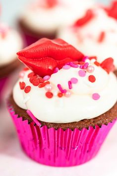 cupcakes with white frosting and red lipstick on top