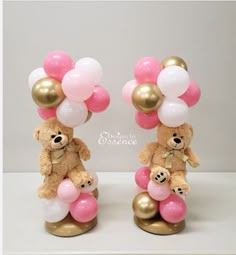 two teddy bears are holding balloons in the shape of hearts