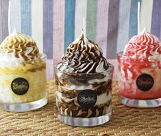 three ice cream sundaes sitting on top of a wicker table next to each other