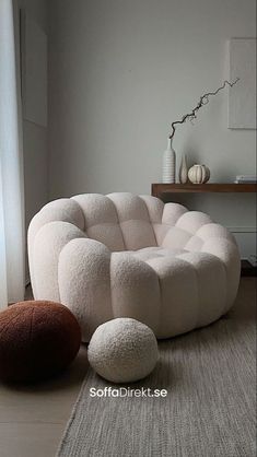 a living room with white furniture and rugs on the floor in front of a window