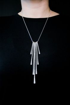 This gorgeous necklace is a show-stopper. The design is simple but the effect is dramatic. I hammer six individual strips of thick, solid Sterling Silver metal into a unique pendant design.The longest piece of the pendant in the center measures approximately 5.5″. This necklace comes with a 100% pure sterling silver snake chain. If you would like a different chain length feel free to let me know! **Length pictured is 16″**This necklace is made out of solid Sterling Silver.This item is made to or Silver Necklace Simple, Handmade Silver Jewellery, Long Silver Necklace, Silver Snake Chain, Unique Pendant, Pendant Design, Gorgeous Necklaces, Snake Chain, Cleaning Jewelry