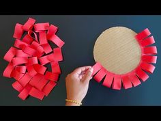 someone is making a wreath out of red paper