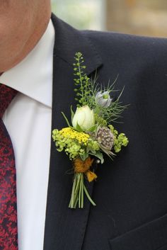 a man wearing a suit and tie with a boutonniere on his lapel