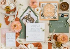 the wedding stationery is laid out with flowers and other things to include an antelope