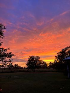 the sun is setting over an open field