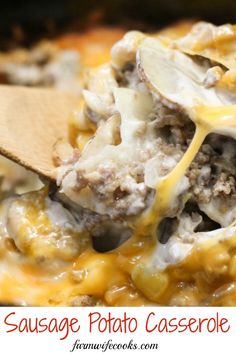 sausage and potato casserole is being scooped with a wooden spoon from the casserole dish