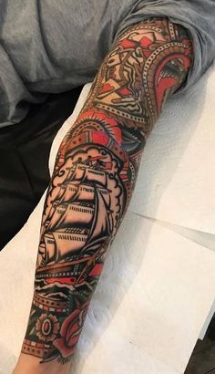 a man's arm with a ship tattoo on it