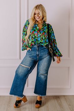 - For a feminine option with luxe vibes add this flowy top to your wardrobe! - Lightweight material with a blue, green, red, and pink hued abstract floral print and a satin finish - A built-in lining - A ruffled v-cut neckline - Long, loose sleeves with elastic cuffs - A relaxed silhouette that ends in a straight hemline Chic Green Tops With Abstract Print, Chic Green Blouse With Abstract Print, Loose Sleeves, Abstract Floral Print, Flowy Top, Flowy Tops, V Cut, V Cuts, Abstract Floral