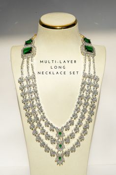 Enhance your bridal look with the luxurious Irma Rhodium Plated & Green Diamante Accent AD Bridal Set - a 5-piece ensemble that exudes elegance and high quality. Crafted with a rhodium-plated silver finish, this exquisite bridal set features green diamante accent AD stones mixed with white AD stones for a captivating contrast. The bridal set includes: Choker Necklace: Adorned with white and green AD stones and beads, offering a stunning centerpiece for your bridal attire. Triple-Layer Long Neckl Emerald Green Stone, Accessories Ear, Bridal Attire, Ear Chain, Chandbali Earrings, Choker Necklace Set, Bridal Look, Jhumka Earrings, Style Classique