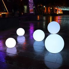 several white balls sitting on the ground at night