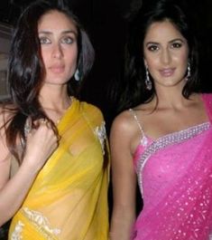 two women in saris posing for the camera with one holding her hand on her hip