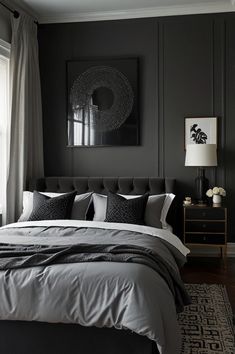 a bedroom with black walls and grey bedding, white pillows and gray throw pillows