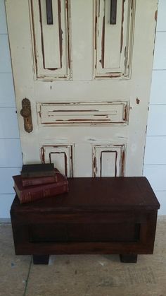 two books are sitting on a bench in front of a door with white paneling