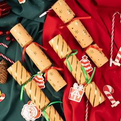 crackers wrapped in brown paper and decorated with candy canes on a red cloth