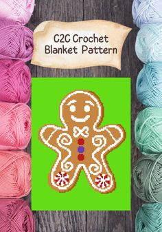 the crochet gingerbread is next to some balls of yarn on a wooden surface