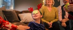 a young boy with reindeer antlers on his head and other people in the background