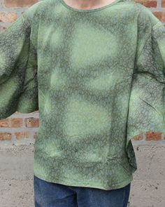 a woman standing in front of a brick wall