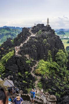 people are walking up the stairs on top of a mountain