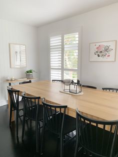 a dining room table with black chairs around it