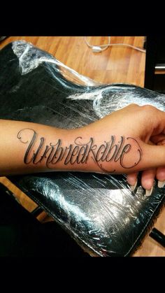 a woman's arm with the word unwrapped on it and her name in cursive font