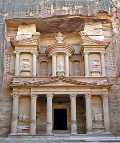 an ancient building carved into the side of a cliff