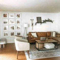 a living room filled with furniture and pictures on the wall above it's coffee table