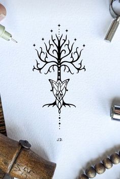 a drawing of a tree on paper next to some wood beads and other things around it