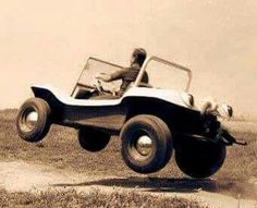 an old photo of a man driving a car in the middle of the day with his dog