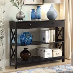 a black shelf with vases on it in front of a mirror and other items