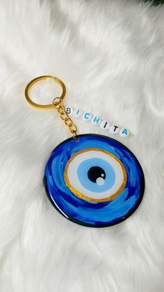 a keychain with an evil eye on it sitting on a white fur surface