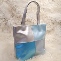 - 100% Pvc - To Clean, Simply Wipe With A Damp Cloth - Gray Interior Lining - Body Of Purse Measures 8 1/2" Tall, 8 1/2" Wide From Side To Side And The Base Is 4 1/4" Thickness From Front To Back - Handles Stand 5 3/4" Above Handbag - Closure Is A Magnetic Snap - No Pockets Inside *This Item Is New And Unused Avon Bags, Gray Interior, Tote Handbag, Silver Blue, Silver Turquoise, Womens Tote Bags, Tote Handbags, Blue And Silver, Inside Pocket