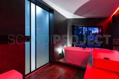 a bathroom with red tub and black walls