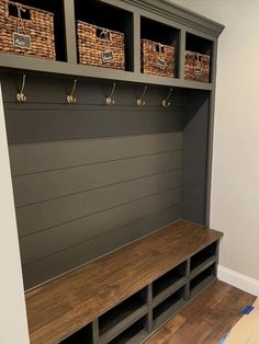 a wooden bench with baskets on the top and two benches below it, along with other storage units