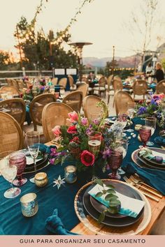 a table set up with plates and place settings for an outdoor dinner party or gathering