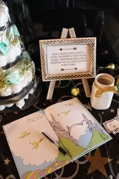 an open book sitting on top of a table next to cupcakes and other items