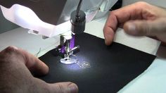 someone is using a sewing machine to sew something on a piece of paper that has been stitched together