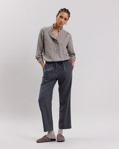 Women's check print wool blend shirt with ruffled collar. Gathers at the back. Half button placket with ruffle details. Long sleeves with single cuffs.