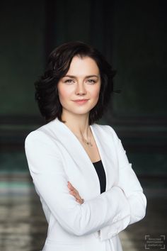 a woman with her arms crossed posing for a photo