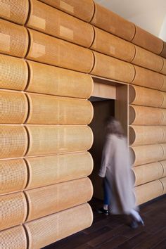 a person walking past a wall made out of wood